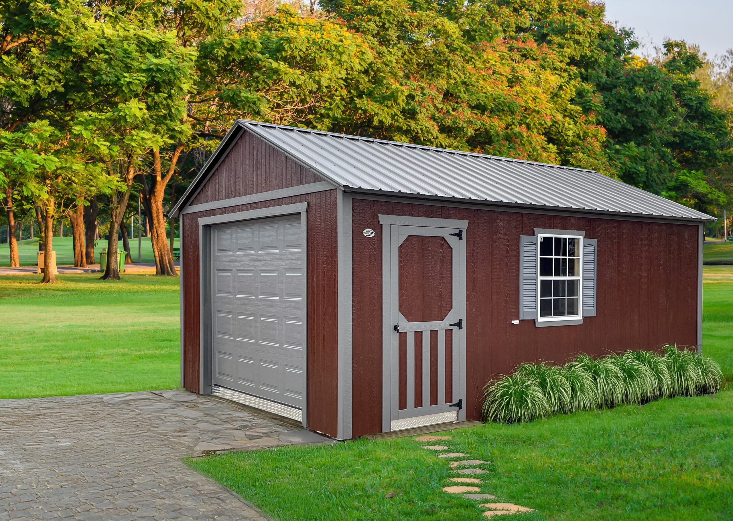 A edited photo of a red garage. It summer and the background showing a lush garden