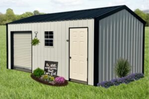 A small, light-colored metal shed with a blue roof sits on a lawn. It has a white door, a garage door, and a window. Plants and a decorative sign are in front.